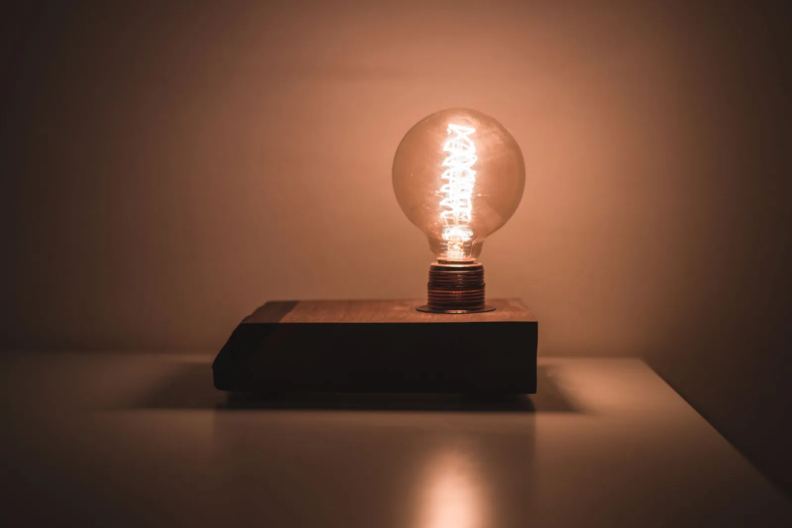 Glowing light bulb on a wooden base