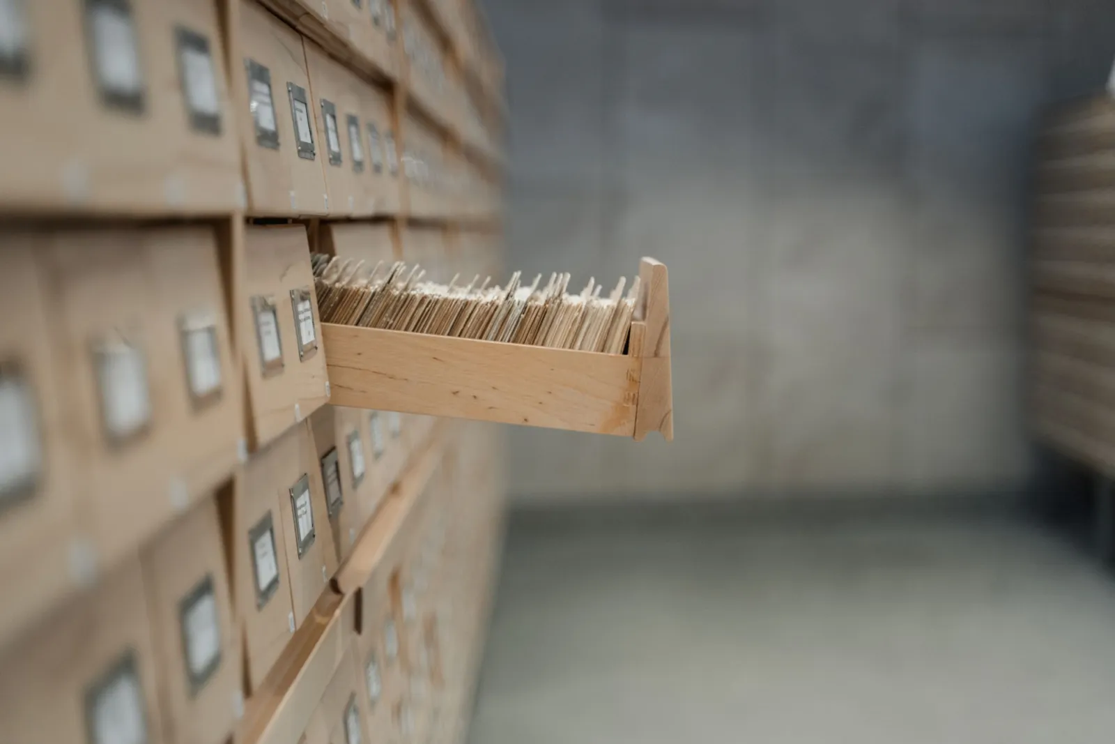 Wooden filing cabinet with an open card index drawer