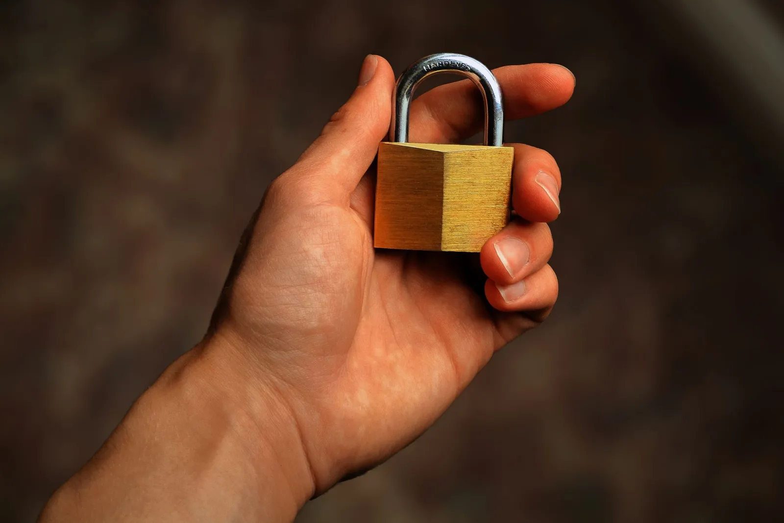 Hand holding a brass padlock