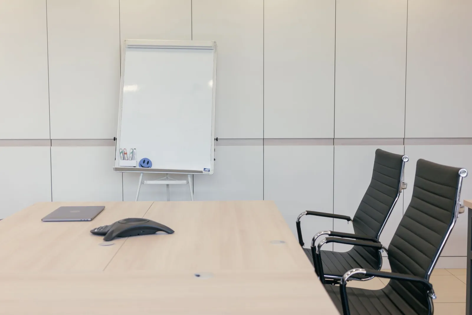 Leerer Sitzungsraum mit Flipchart und zwei Stühlen