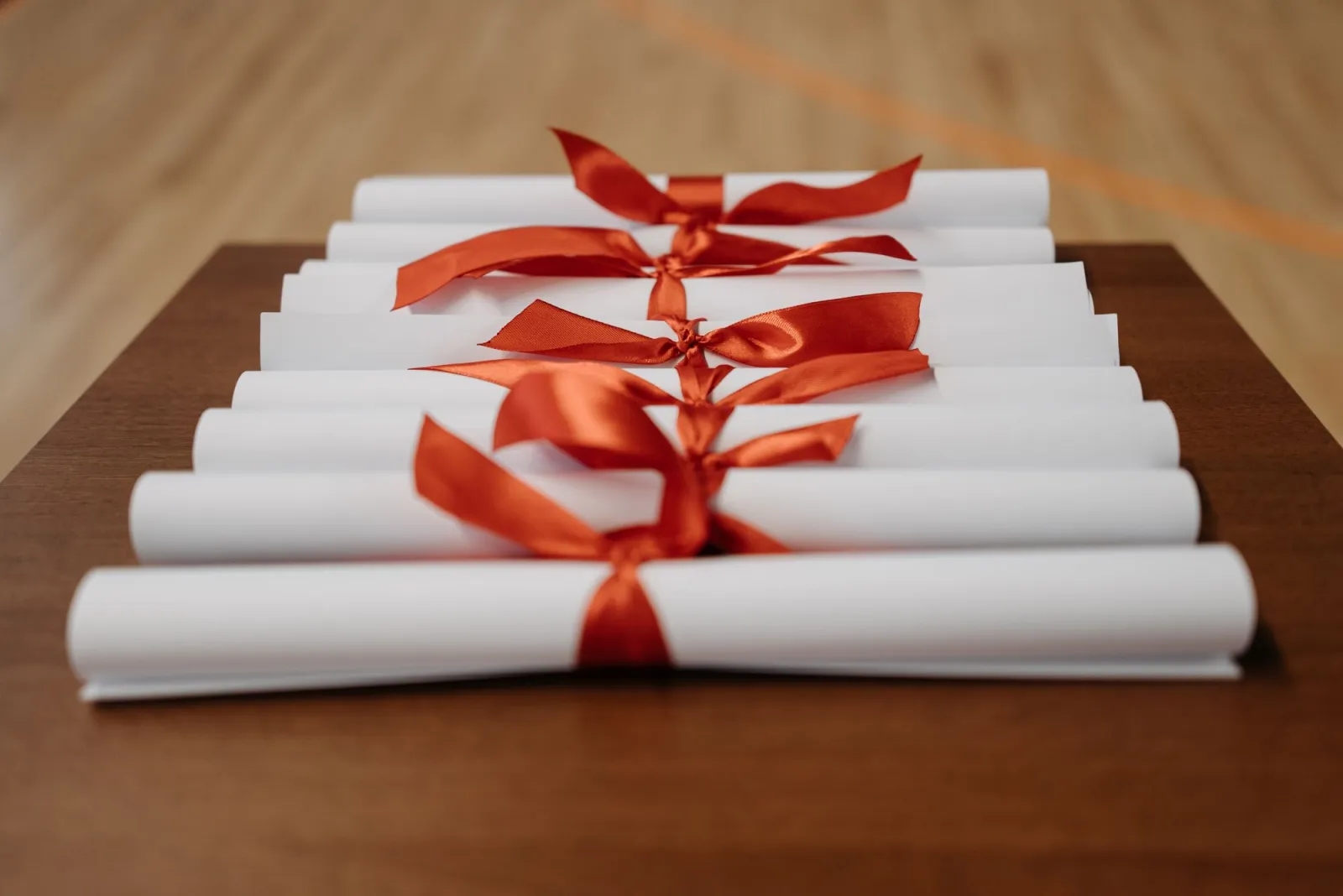 Rolled-up certificates with red ribbons on a table